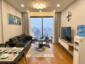 un salon avec un canapé et une télévision dans l'établissement QMP - Vinhomes D'Capitale Tran Duy Hung, à Hanoï