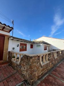 a white house with a stone retaining wall at Posada Santa Lucía de Cucaita in Cucaita