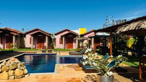 a house with a swimming pool in front of it at POUSADA DONNA MARIA in São Miguel do Gostoso
