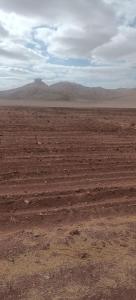 an empty desert with a mountain in the distance at ama in Ismant +6 photos