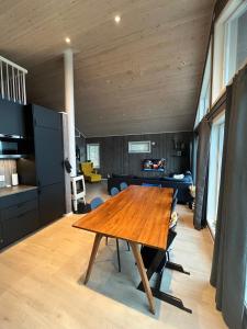 a living room with a wooden table and a kitchen at Modern chalet in Malangen in Mestervik +17 photos