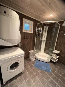 a bathroom with a shower and a washing machine at Modern chalet in Malangen in Mestervik