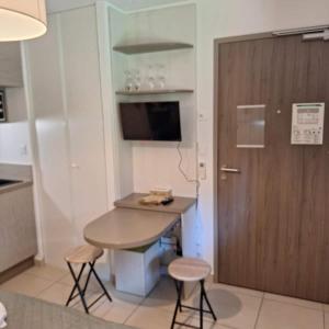 a kitchen with a table and two stools and a door at Studio Residence du Pont du Gard in Remoulins +7 photos