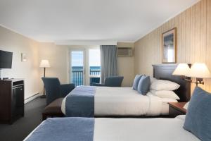 a hotel room with two beds and a balcony at The Sparhawk Oceanfront Resort in Ogunquit