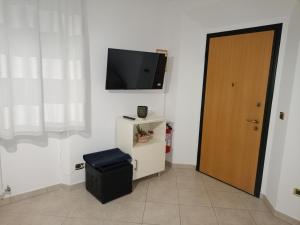 a room with a flat screen tv and a door at Da Margot - Appartamento al mare in Grottammare