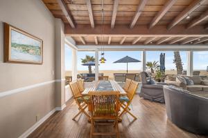 ニューポートビーチにあるLuxurious Oceanfront Home with Incredible Viewsのテーブルと椅子とソファのあるダイニングルーム