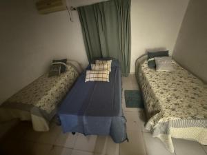 two twin beds in a room with a window at Victoria Apart in Esquina