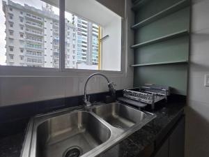 a kitchen with a stainless steel sink and a window at Charming Apartment on the Cinta Costera N#5 in Panama City +64 photos