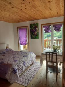 a bedroom with a bed and a table and windows at La Nave B&B in Monteggio
