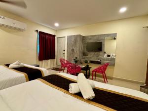 a hotel room with two beds and a television at Royal Dreams Beach View in Pondicherry