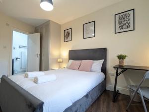 a bedroom with a large white bed with a desk at 2 Ensuite Bedroom House Near Centre Free Parking in York