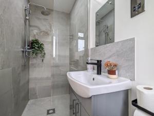 a white bathroom with a sink and a shower at 2 Ensuite Bedroom House Near Centre Free Parking in York +19 photos