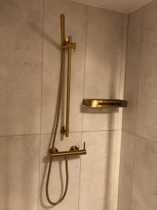 a shower with a hose attached to a wall at Moja Stay - wyjątkowy dom z sauną in Niesulice +38 photos