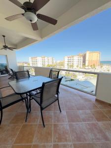 a dining room with a table and chairs on a balcony at Girasol Maximilian en la Playa Sandy Beach in Puerto Peñasco