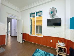 a living room with a flat screen tv on a wall at Khách Sạn NANI in Da Lat