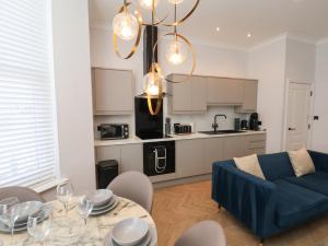 スカーバラにあるThe Salisbury sleeps 4 Classic Apartmentの青いソファとテーブルのあるリビングルーム +18枚の写真