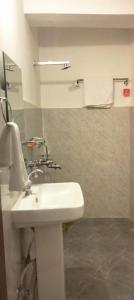 a white bathroom with a sink and a mirror at Yummy land guest house in Imphal +8 photos