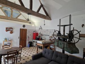 a living room with a couch and a kitchen at Le Pressoir in Turquant