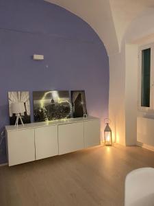 een woonkamer met een witte kast en een lamp bij Sole Mio in Sanremo