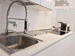 een roestvrijstalen wastafel in een witte keuken bij Sole Mio in Sanremo +19 foto's