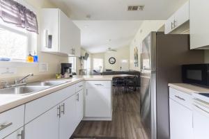 a kitchen with white cabinets and a stainless steel refrigerator at Air Haus LITE in Fourth Crossing