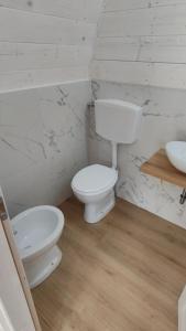 un bagno bianco con un water e un lavandino di Camping Luni a Marina di Massa Altre 29 foto