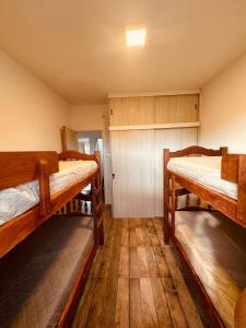 two bunk beds in a room with wooden floors at esfuerzo in La Punta