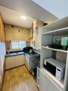 a kitchen with a microwave and a stove top oven at esfuerzo in La Punta