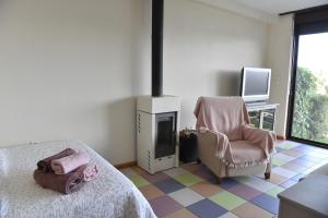 a bedroom with a bed and a chair and a television at AEGEAN view ! in Kavála