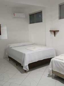 a white room with a bed in a room at Casas Cocos da Primeira Praia 2 in Cayru