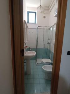 Un baño con lavabo, inodoro y ducha. en Suite del Borgo, en Otranto