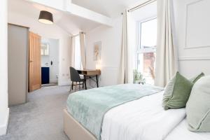 a white bedroom with a bed and a desk at Archies Cozy Retreat A Stylish Derby Hideaway in Derby