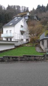 a white house on a hill next to a house at Ferienwohnung Mergel in Black Forest in Zell im Wiesental