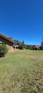 a field of grass with a building in the background at Rincón de los Sueños in Villa General Belgrano +12 photos