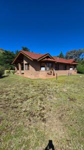 a house sitting on top of a grass field at Rincón de los Sueños in Villa General Belgrano