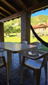 a table and chairs on a patio with a hammock at Rincón de los Sueños in Villa General Belgrano