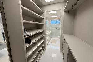 a walk in closet with white counters and shelves at Ed. Premium in Curro Velho +59 photos