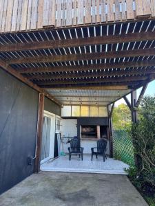 a patio with two chairs under a wooden pergola at Caleta Olivia in Mar de Cobo