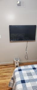 a bedroom with a flat screen tv on the wall at Happiness queen room 3 in Newark