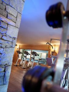 a row of exercise bikes in a room with a stone wall at CGH Résidences & Spas Les Chalets de Jouvence in Les Carroz d'Araches