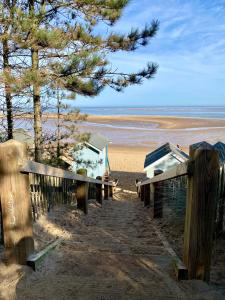 a view of a beach with benches and trees at The Old Barn Apartment in Wells next the Sea