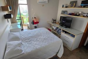 a small bedroom with a bed and a tv at Ed. Delta Gardenn in Carmo +11 photos