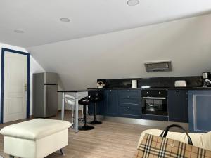 una cucina con mobili blu e tavolo di O Cantinho da Cotovia a Valpaços Altre 16 foto