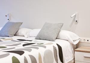 a white bed with pillows on top of it at Arima Apartamentuak 1, Moderno, accesible in Getaria