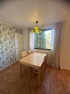 a dining room with a wooden table and a window at Villa Campari in Imatra +17 photos