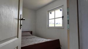 a small bedroom with a bed and a window at MILOSEV KONAk kuća na jezeru in Knić