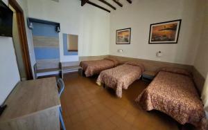 a room with three beds and a table at Hotel Lea in Grosseto +29 photos