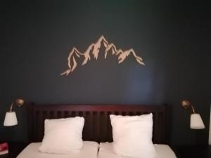 a bedroom with two beds and a mountain mural on the wall at Das Eulennest in Sankt Andreasberg