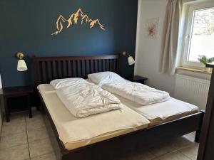 a bedroom with a bed with white sheets on it at Das Eulennest in Sankt Andreasberg +28 photos