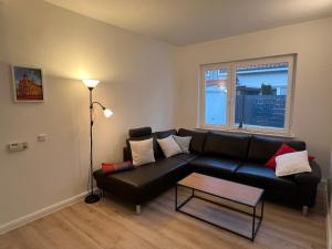 a living room with a black couch and a table at Etzhorner Tied 3 in Oldenburg